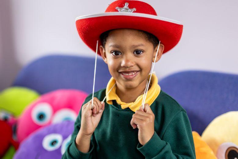 Picture of a boy in school uniform wearing a cowboy hat