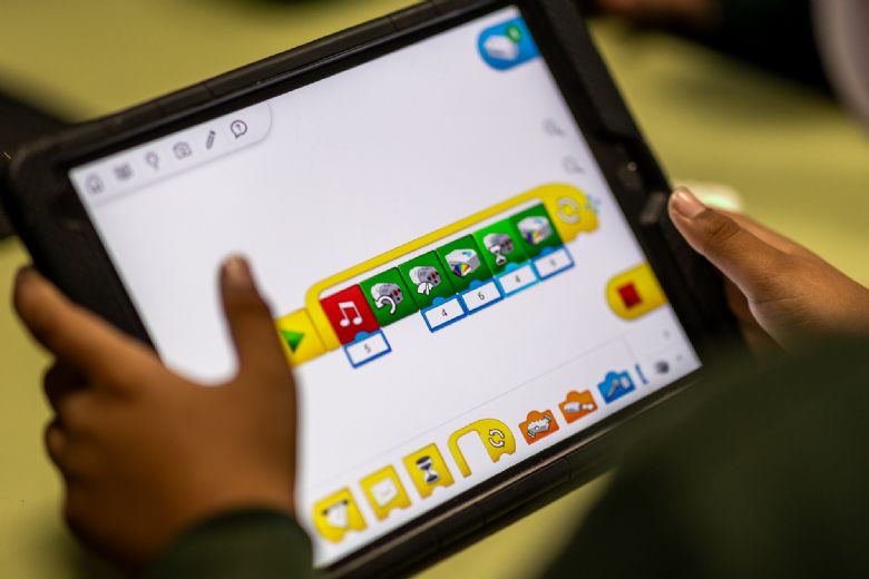 a tablet screen shows programming instructions